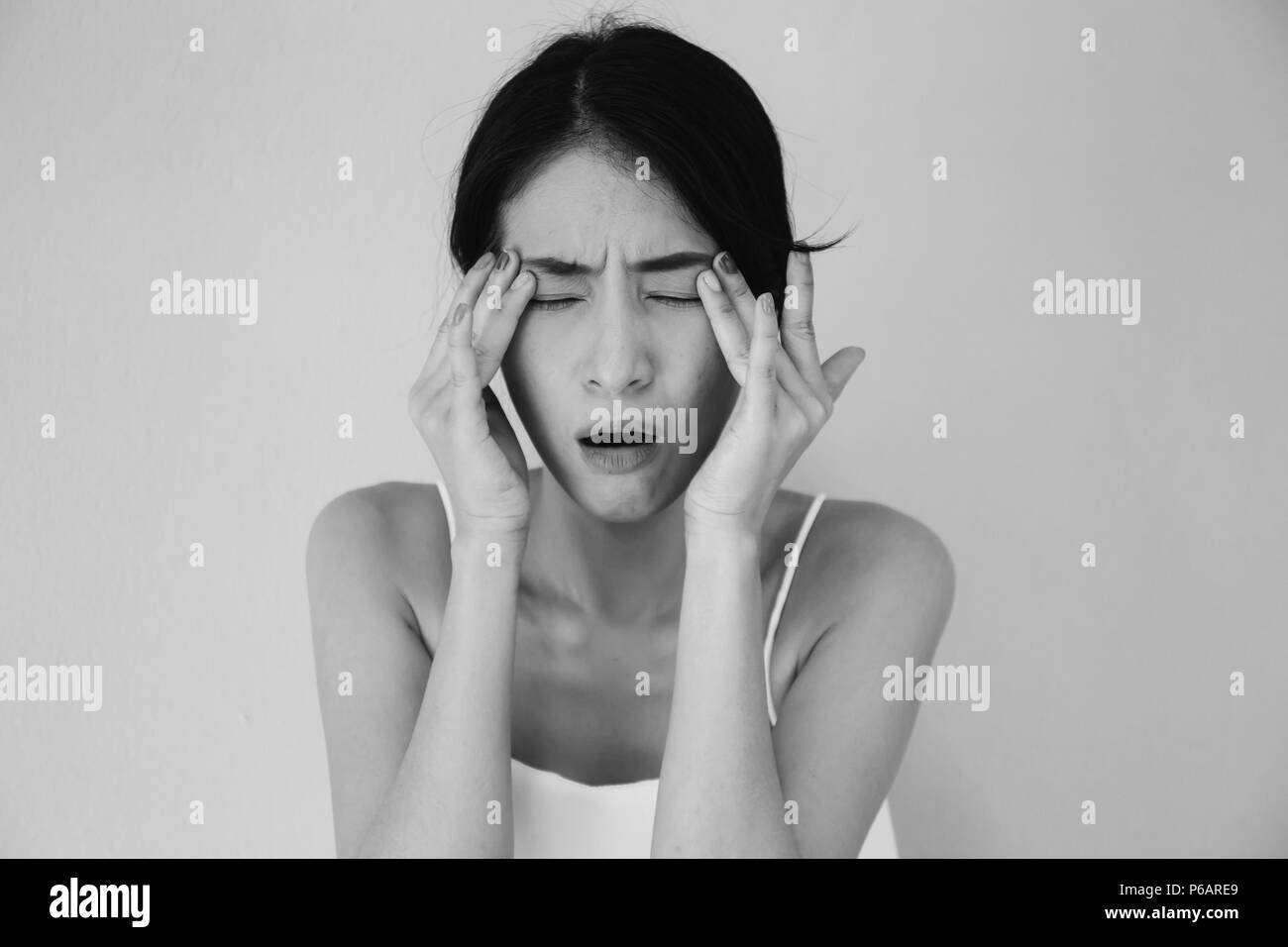 Junge asiatische Frau mit Schmerzen am Auge und Soreness in schwarzen und weißen Ton - Gesundheitswesen und medizinische Konzept Stockfoto