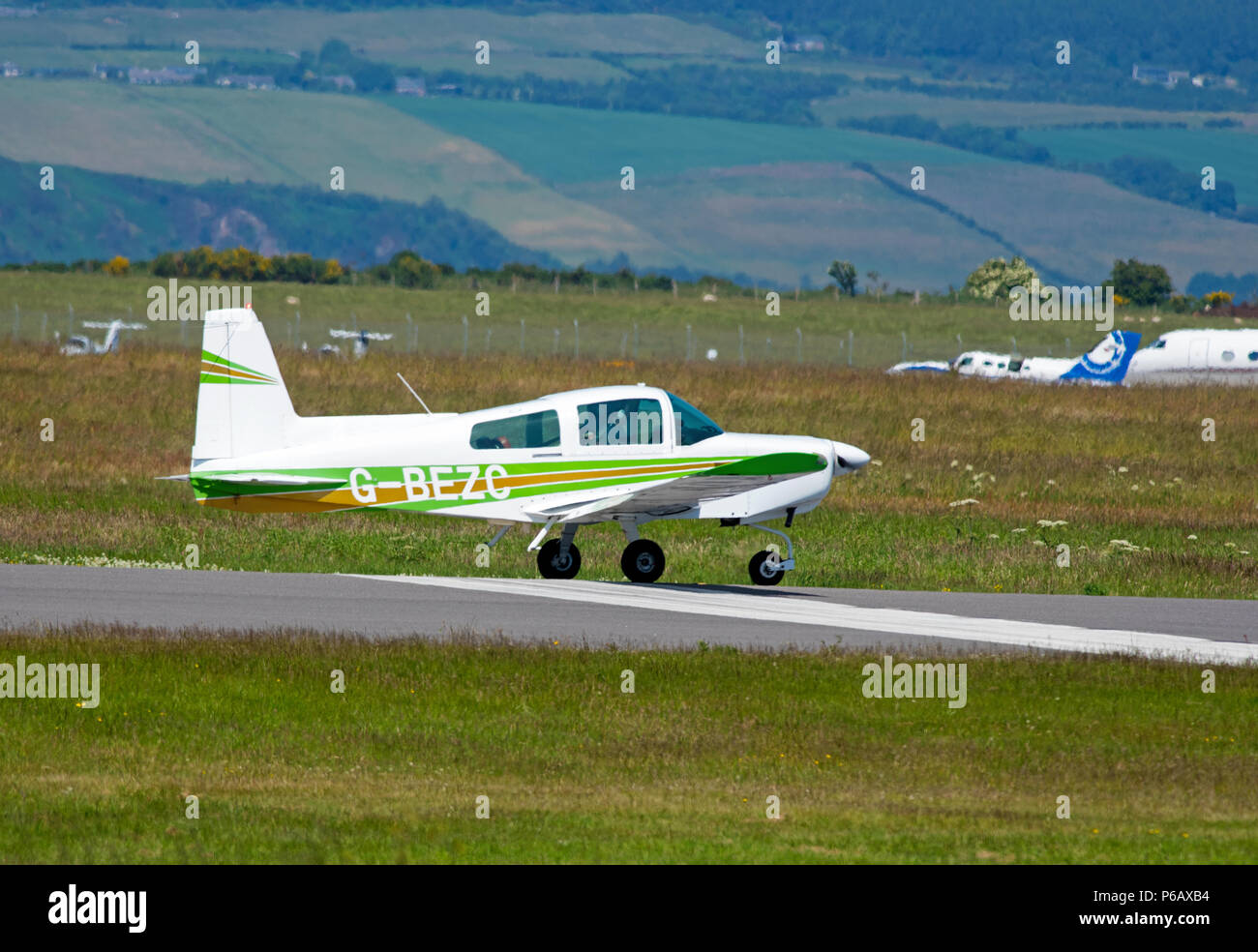Eine Grumman AA5-Traveller light 4 Sitz private Flugzeuge landen in Inverness Dalcross Flughafen in den schottischen Highlands. Stockfoto