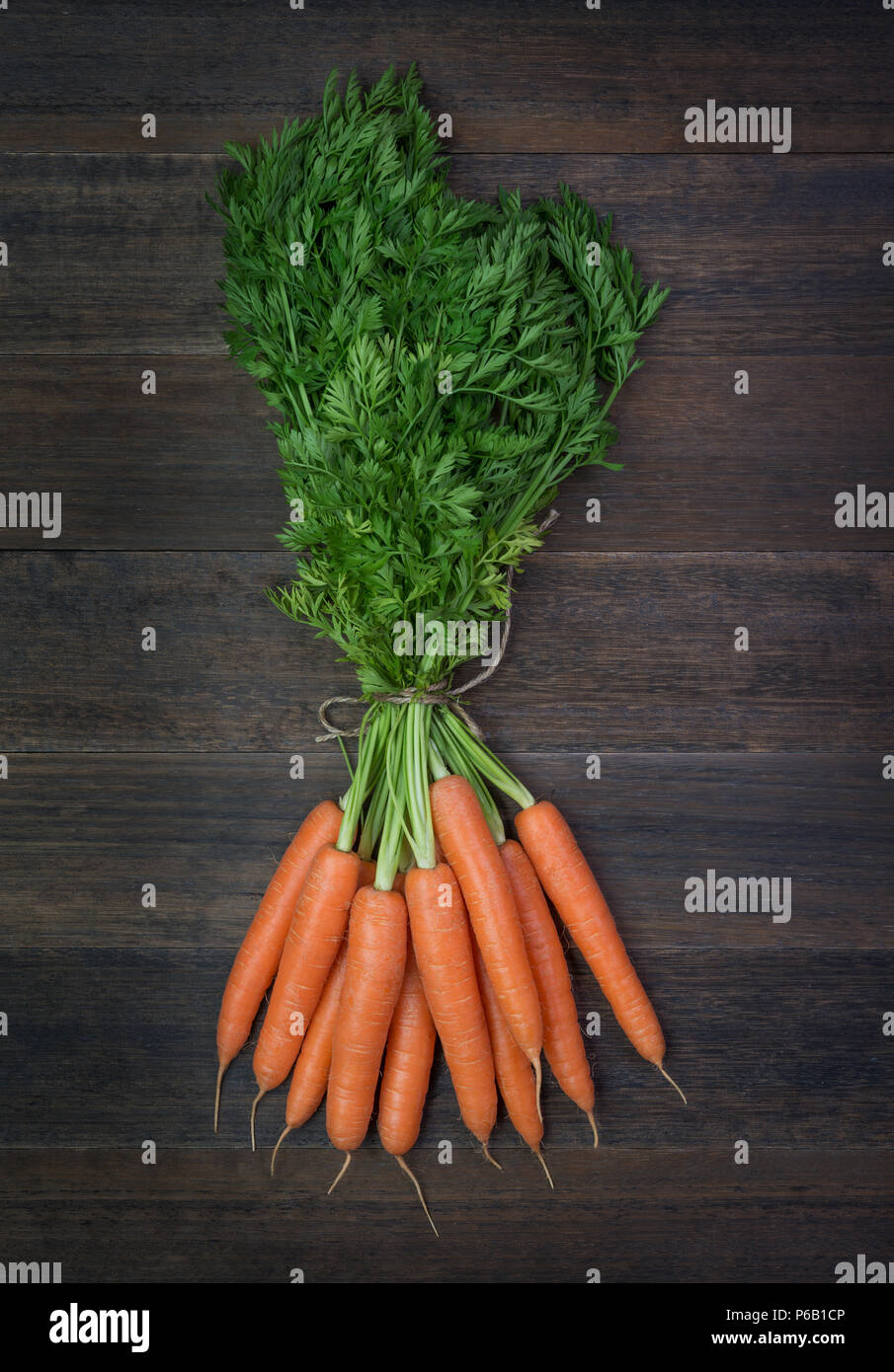 Bündel frische Karotten Gemüse mit grünen Blättern auf rustikalen hölzernen Hintergrund Stockfoto