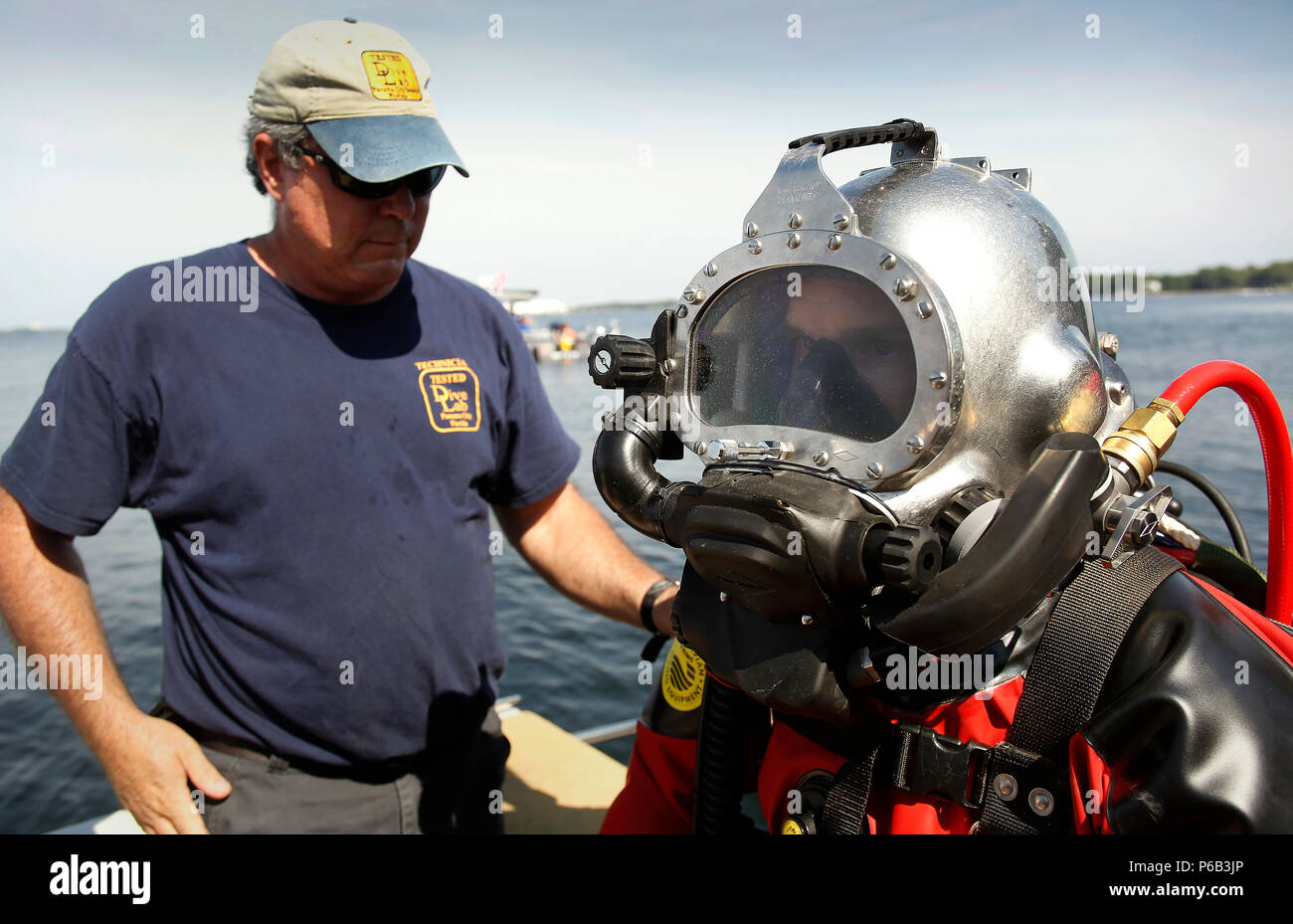 Rocky Heikkinen von Dive Labor prüft über US Border Patrol-Agent Carl Newmayer der BORSTAR dive Team als Newmayer zieht ein HAZMAT Dry Suit in der Nähe von Panama City, Fla., 25. Mai 2016. CBP Foto von Glenn Fawcett Stockfoto