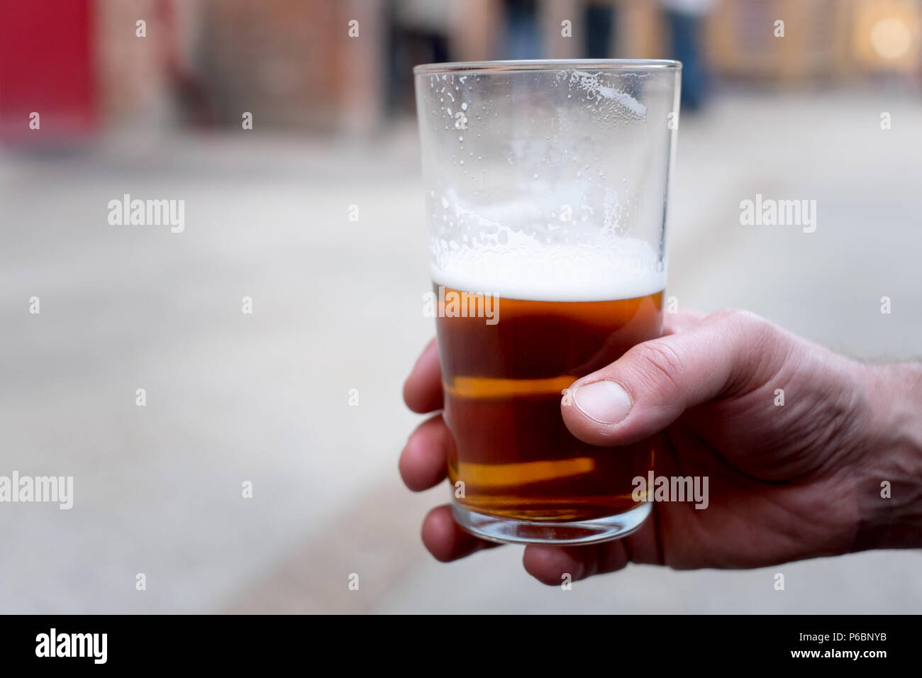 Eine männliche Hand mit einem Pint cask Ale/Handwerk Bier Stockfoto