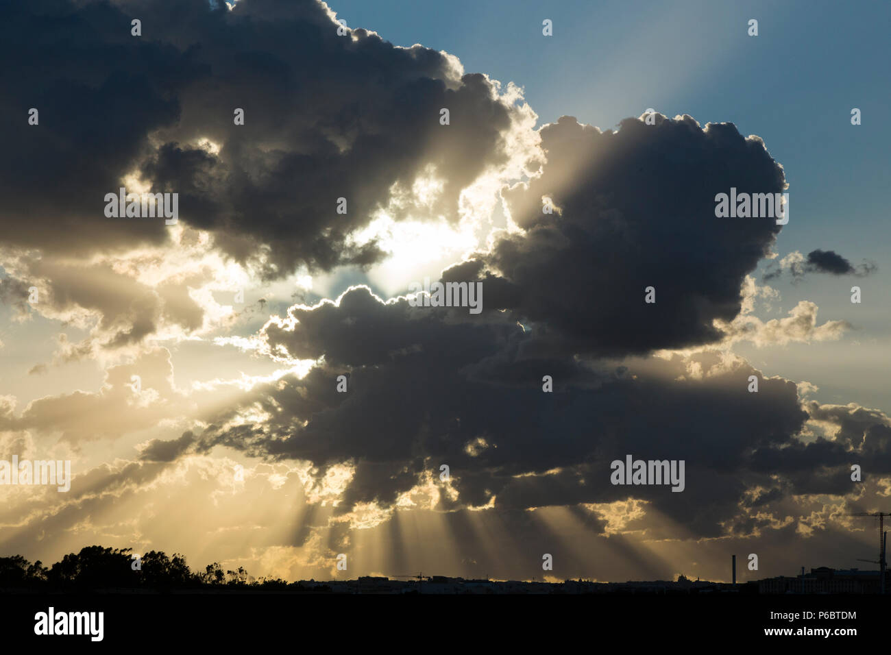 Große Grau/Grau/Schwarz (vielleicht Cumuluswolken) schwere Gewitterwolken über der Skyline von Valletta bei Sonnenuntergang/sun Form produzieren Sonnenstrahlen. Valletta, Malta Stockfoto