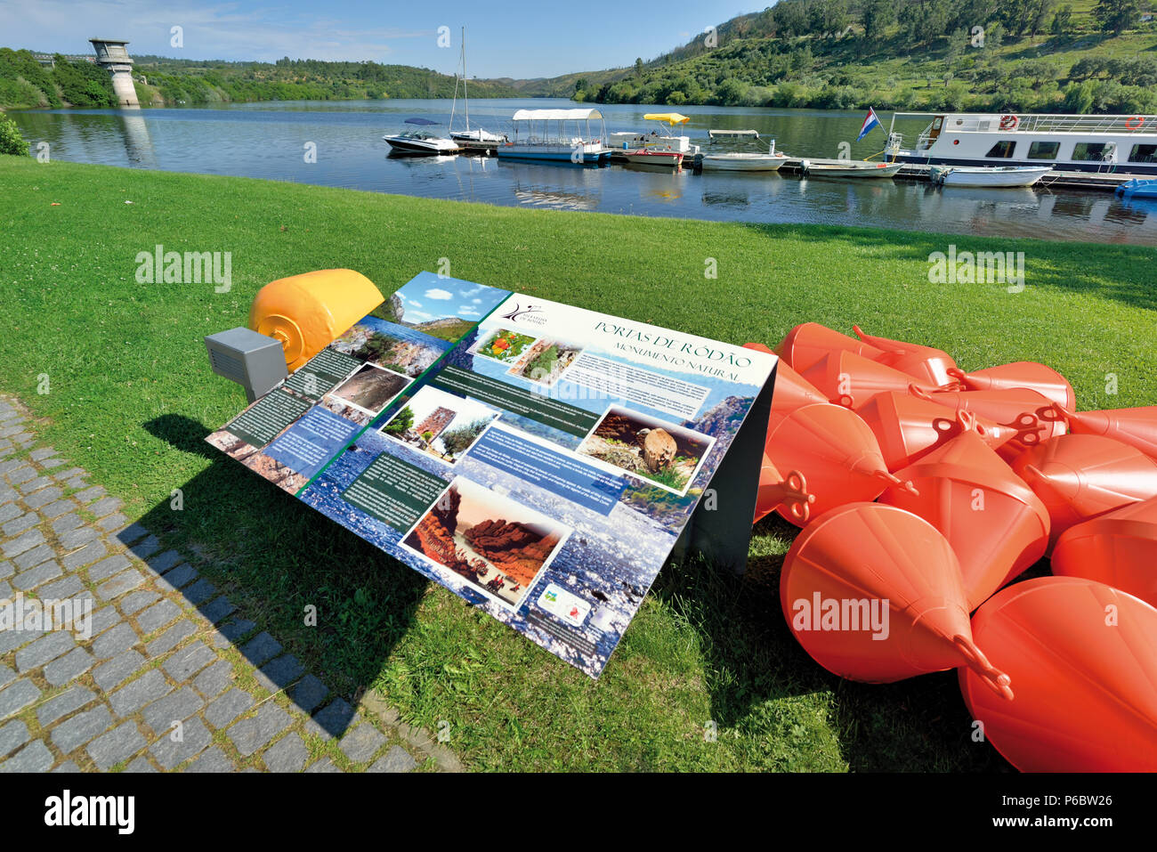 Buntes Plakat und Blick auf riverboats Verankerung in einem kleinen Dock Stockfoto