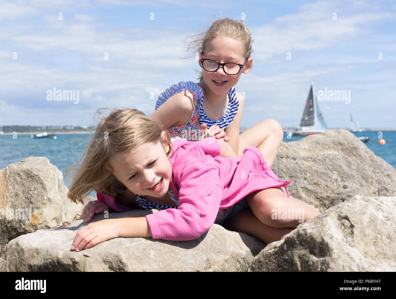 Zwei Schwestern liegen auf Felsen am Meer Stockfoto