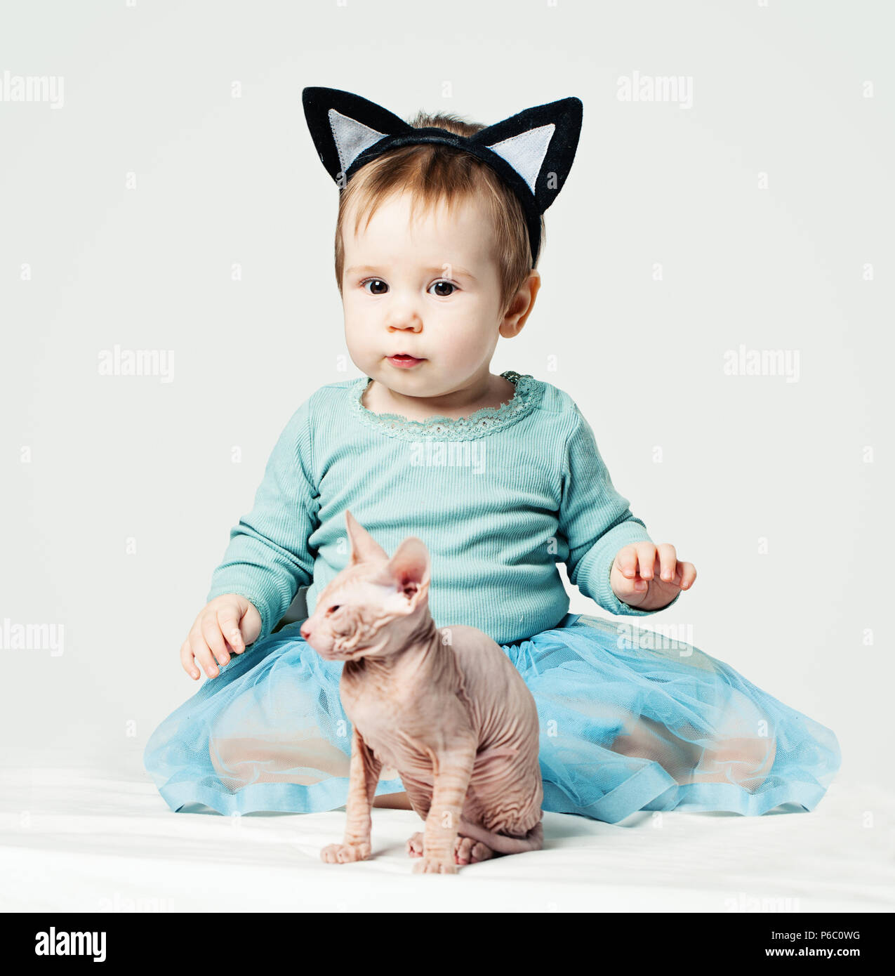 Attraktive Baby Mädchen mit Katze auf Weiß Stockfoto