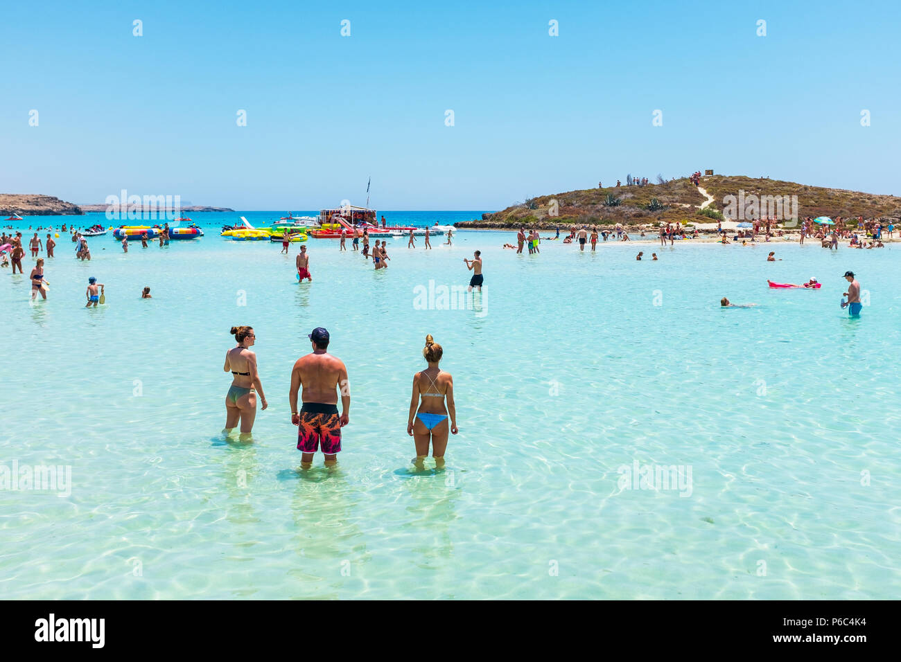 Touristen schwimmen im Meer bei Nissi Bay, Nissi Beach, in der Nähe von Ayiaa Napa, Zypern Stockfoto