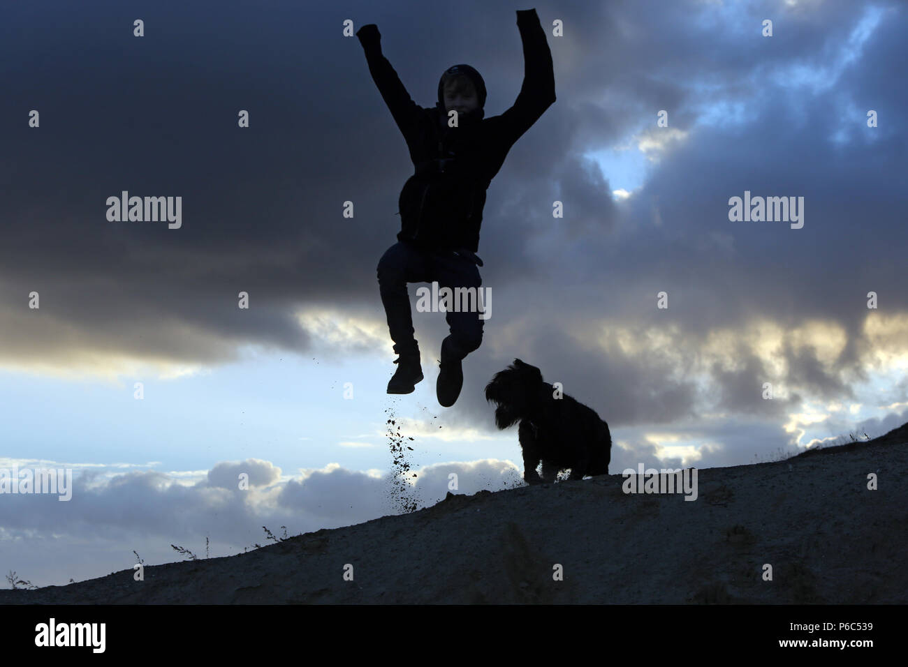 Wustrow, Deutschland - Silhouette, Junge macht eine Air Jump Stockfoto