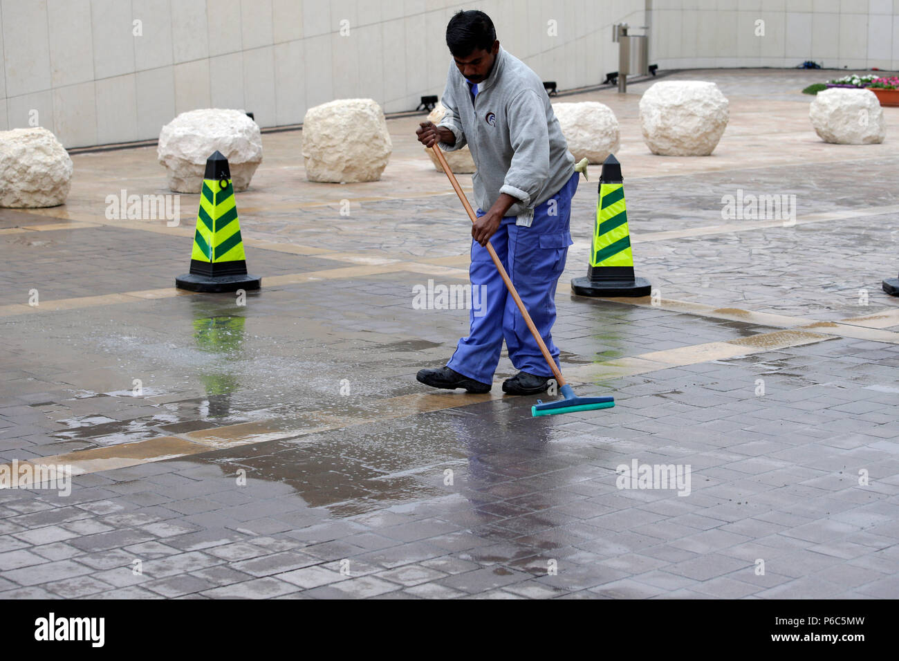 Doha, Katar, man reinigt einen Parkplatz Stockfoto