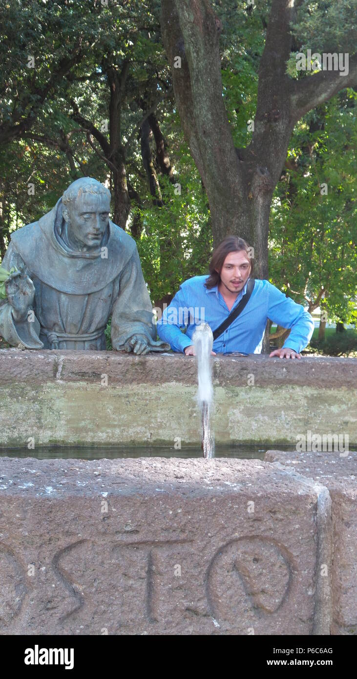 Eine Person, die neben einer Statue ein gut beobachten stehend Stockfoto
