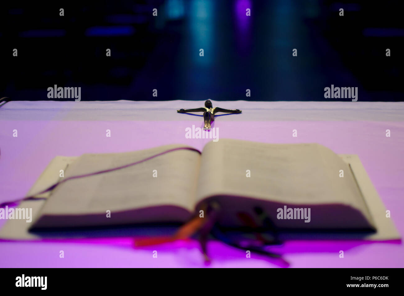 Kreuz hinter einem Buch, das auf dem Altar am Kreuz konzentrierte sich der Rest defokussierten Stockfoto