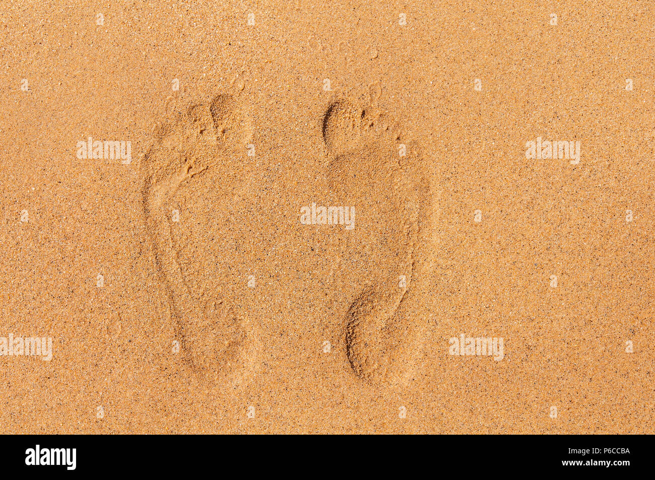 Zwei Fußspuren im Sand am Strand Stockfotografie - Alamy