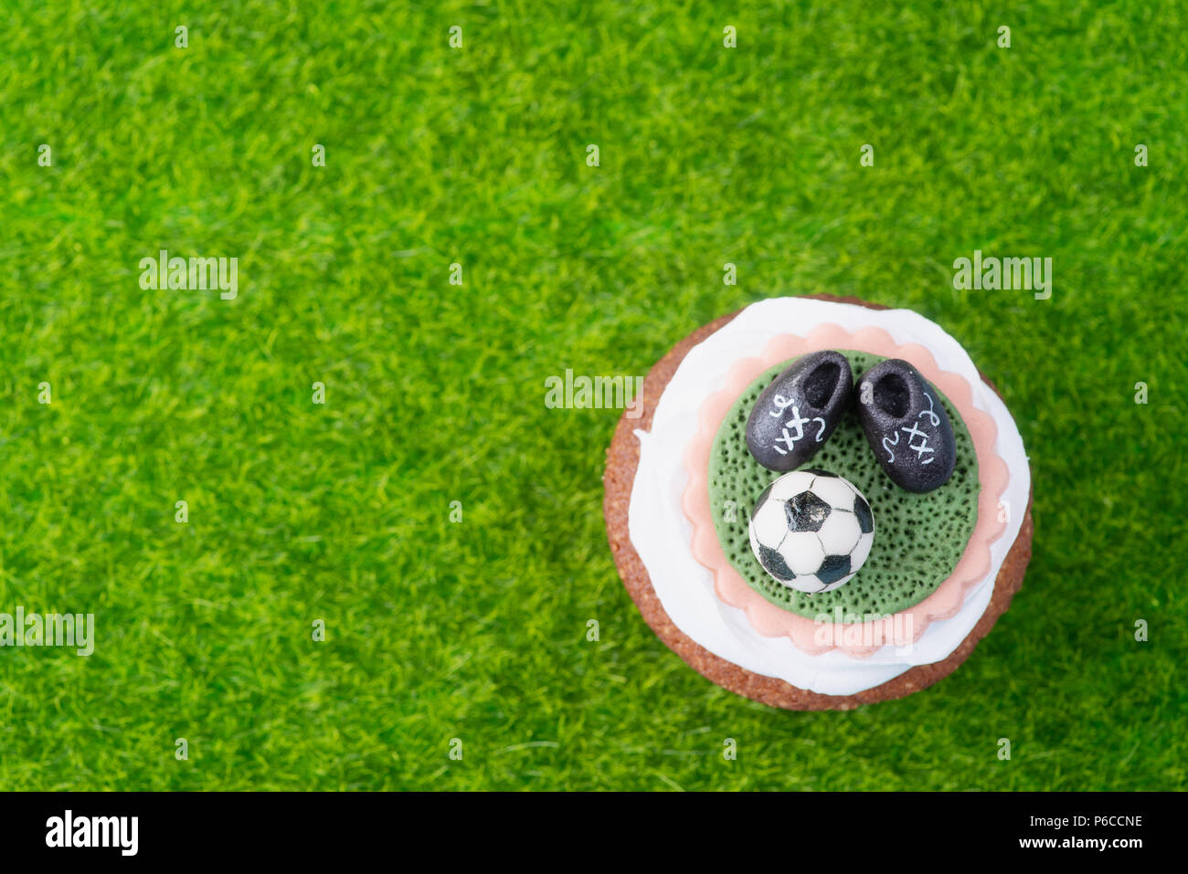 Cupcake im Fußball Stil auf grünem Gras - Ansicht von oben Stockfoto