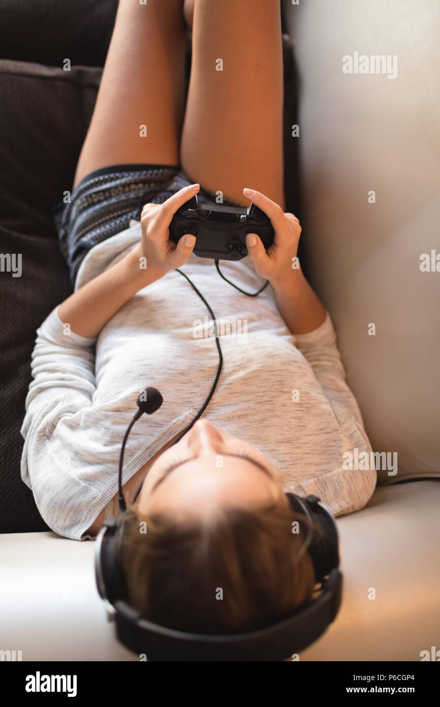 Frau spielen video game mit Headset im Wohnzimmer Stockfoto