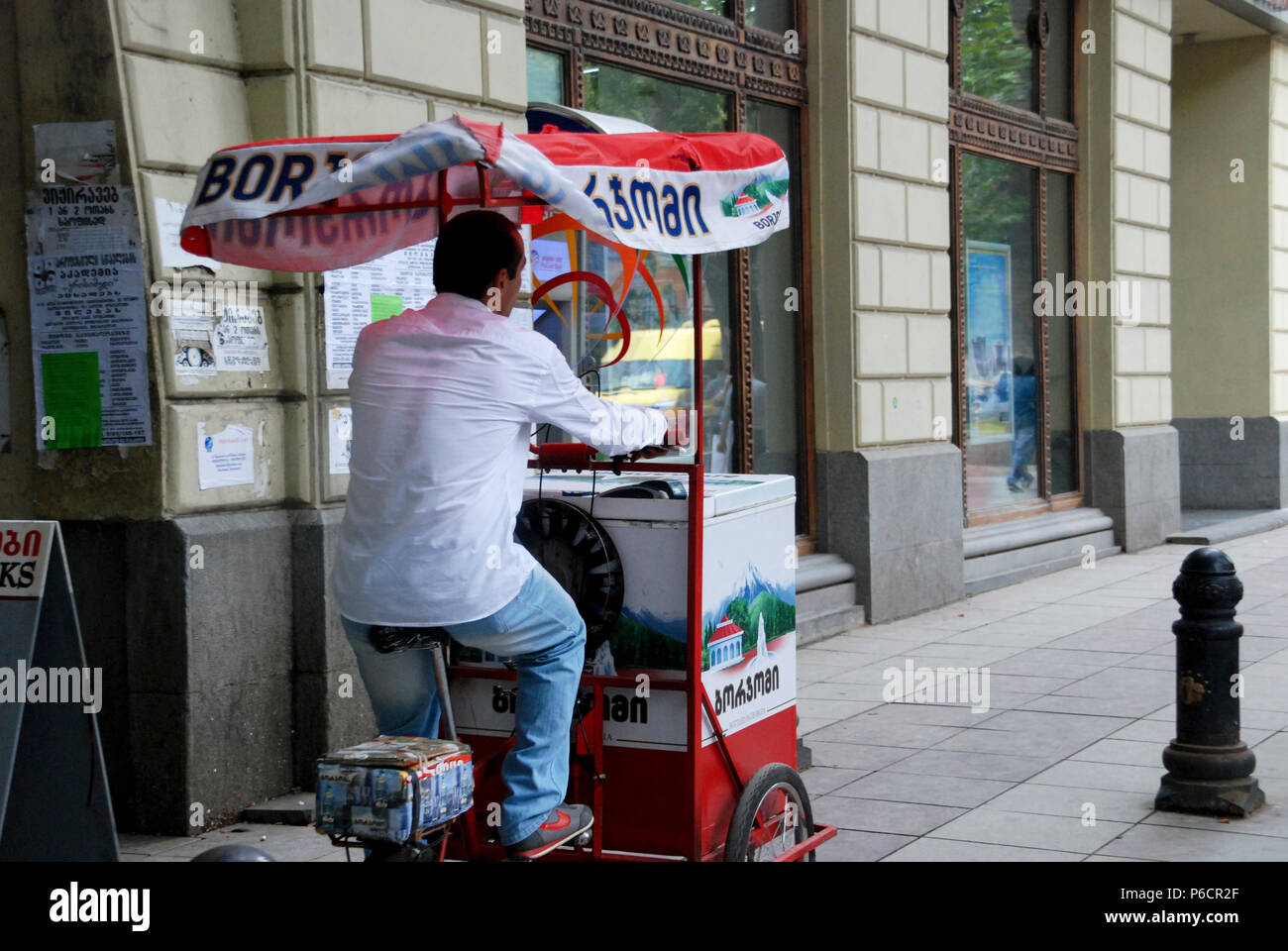 Ein Mann, der borjomi Wasser Warenkorb in Tiflis, Georgien. Stockfoto