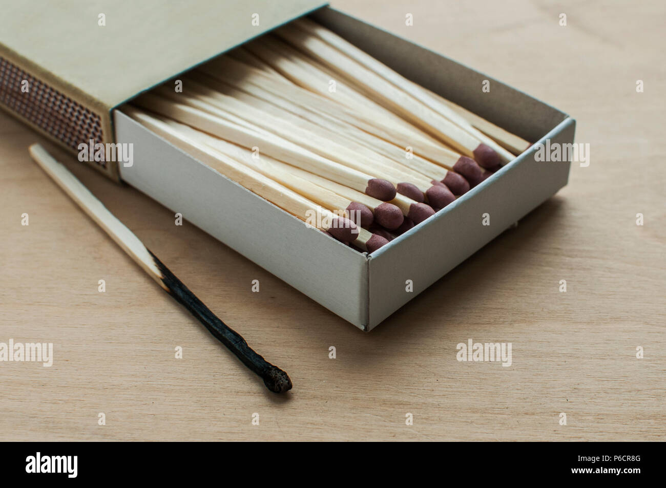 Langen hölzernen Sicherheit Streichhölzer und eine verbrannte Streichholz  in Karton Streichholzschachtel gestapelt auf Holz- Hintergrund  Stockfotografie - Alamy