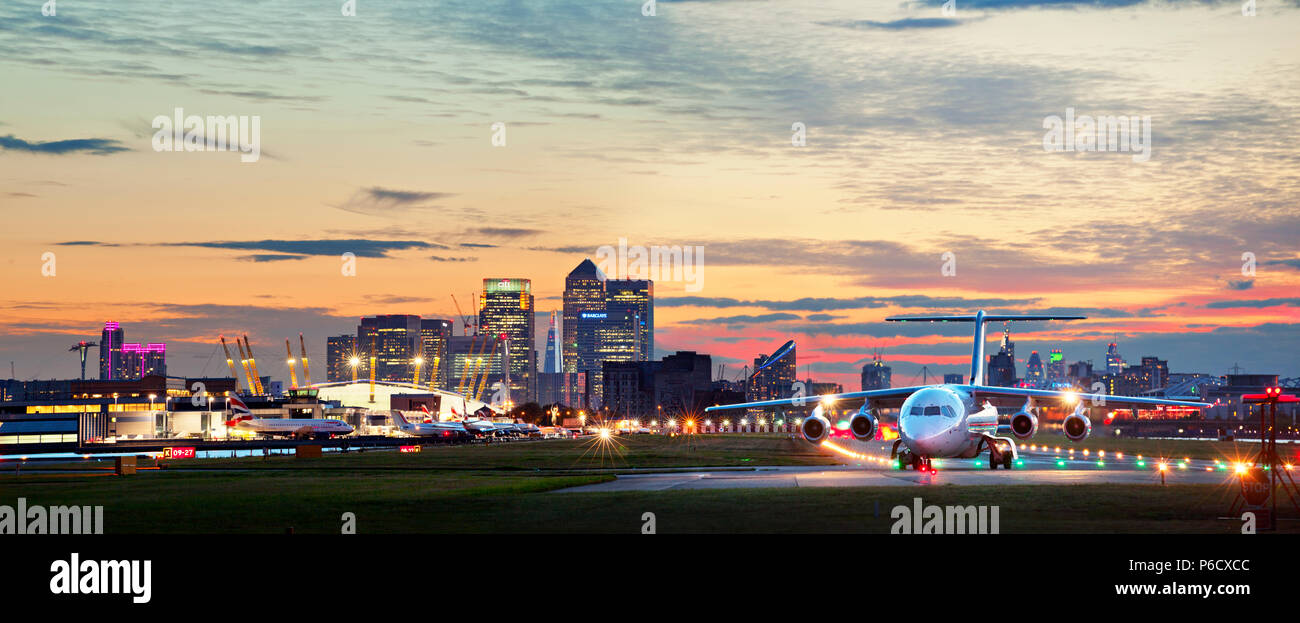 London City Airport mit der Skyline der Docklands und der Square Mile oder die Stadt im Hintergrund. Stockfoto
