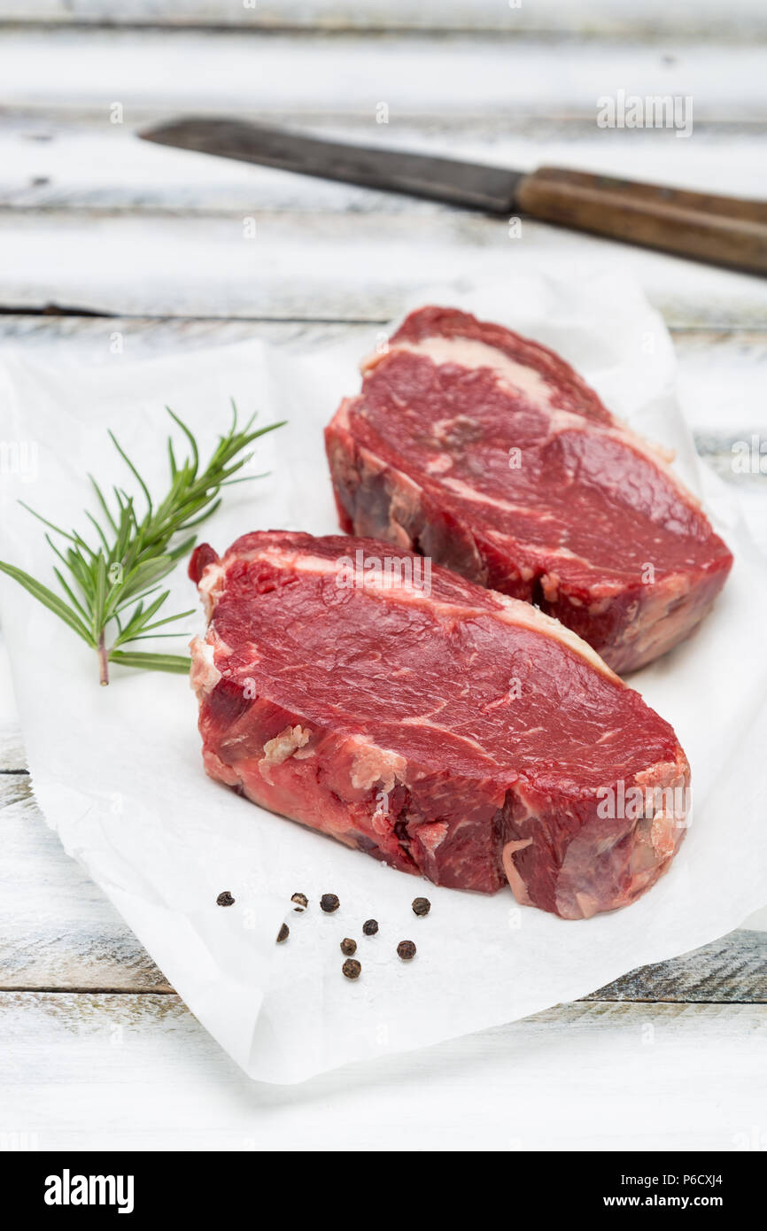 Trocken im Alter von Rib Eye Steak roh auf Papier und Holz- Hintergrund. Stockfoto