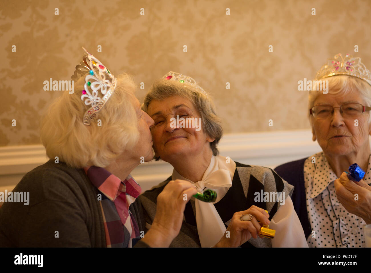 Ältere Frau küssen ihr älterer Freund während der Geburtstagsfeier Stockfoto