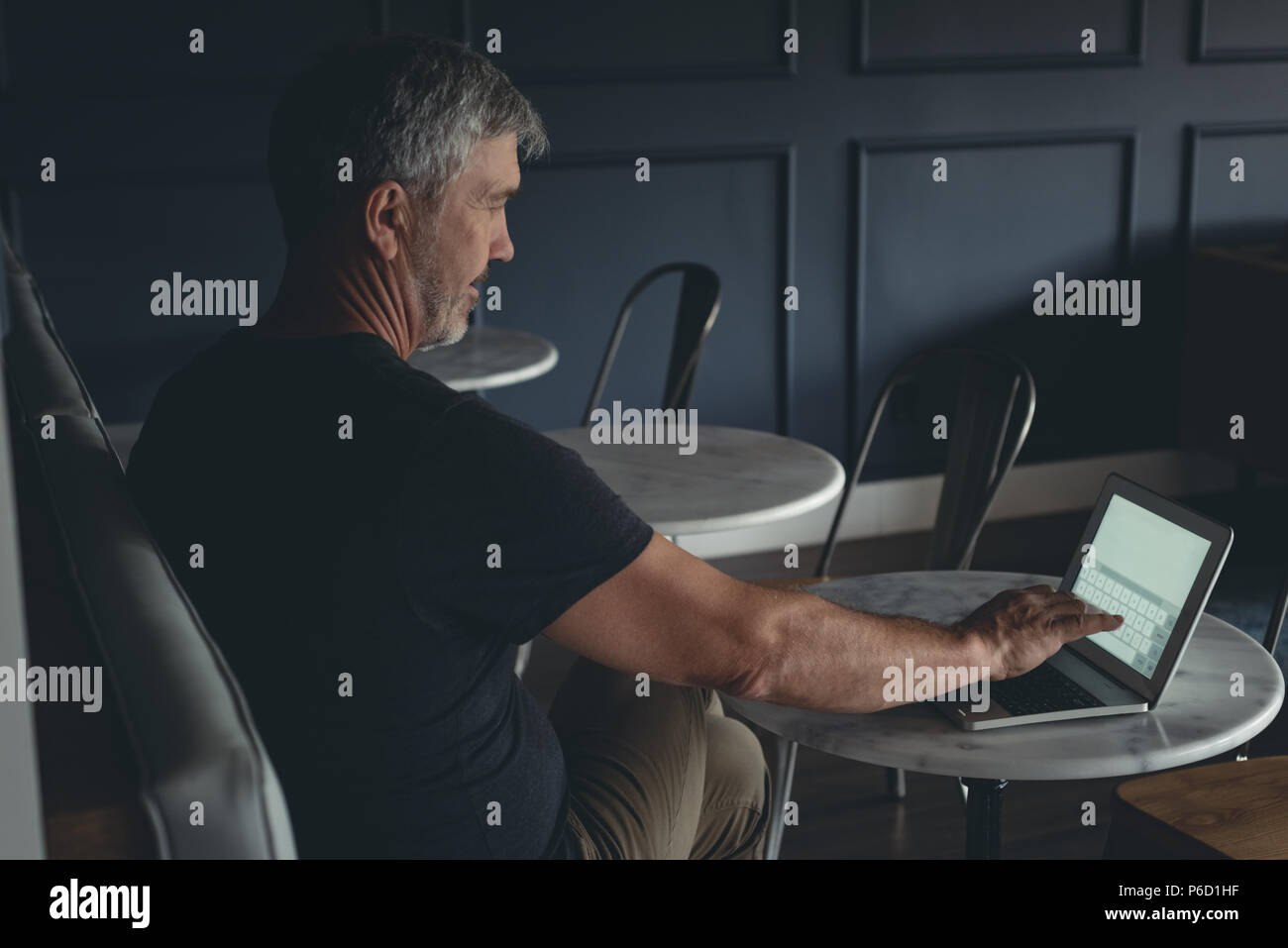 Geschäftsmann mit Laptop in cafeteria Stockfoto