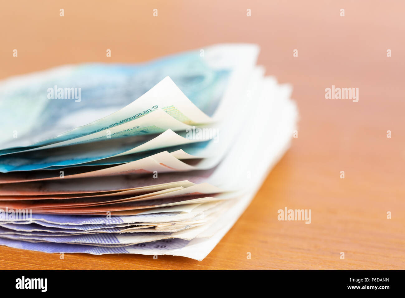 Stapel der verschiedenen britischen Banknoten auf einem Tisch Stockfoto