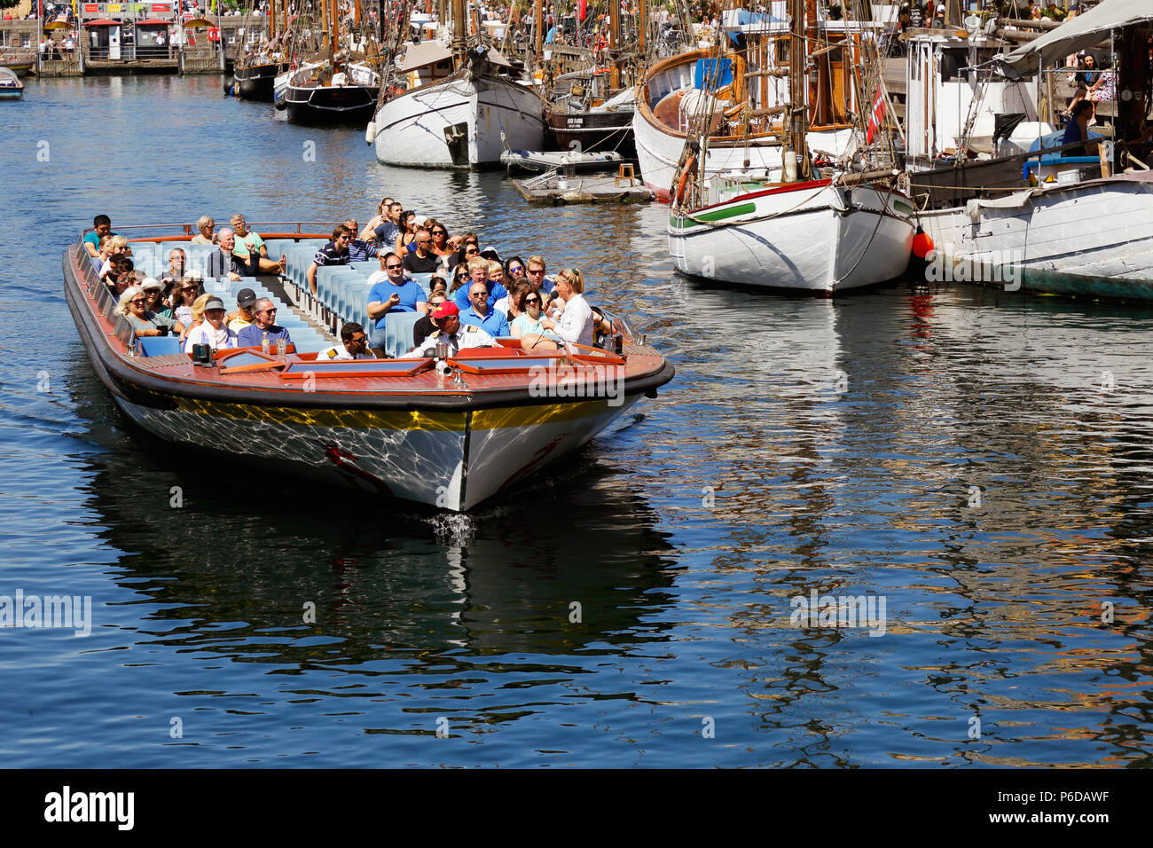 Kopenhagen, Dänemark - 27. Juni 2018: Touristen in einem oben offenen Schiff im Kanal Tour Service am Nyhavn Harbour. Stockfoto