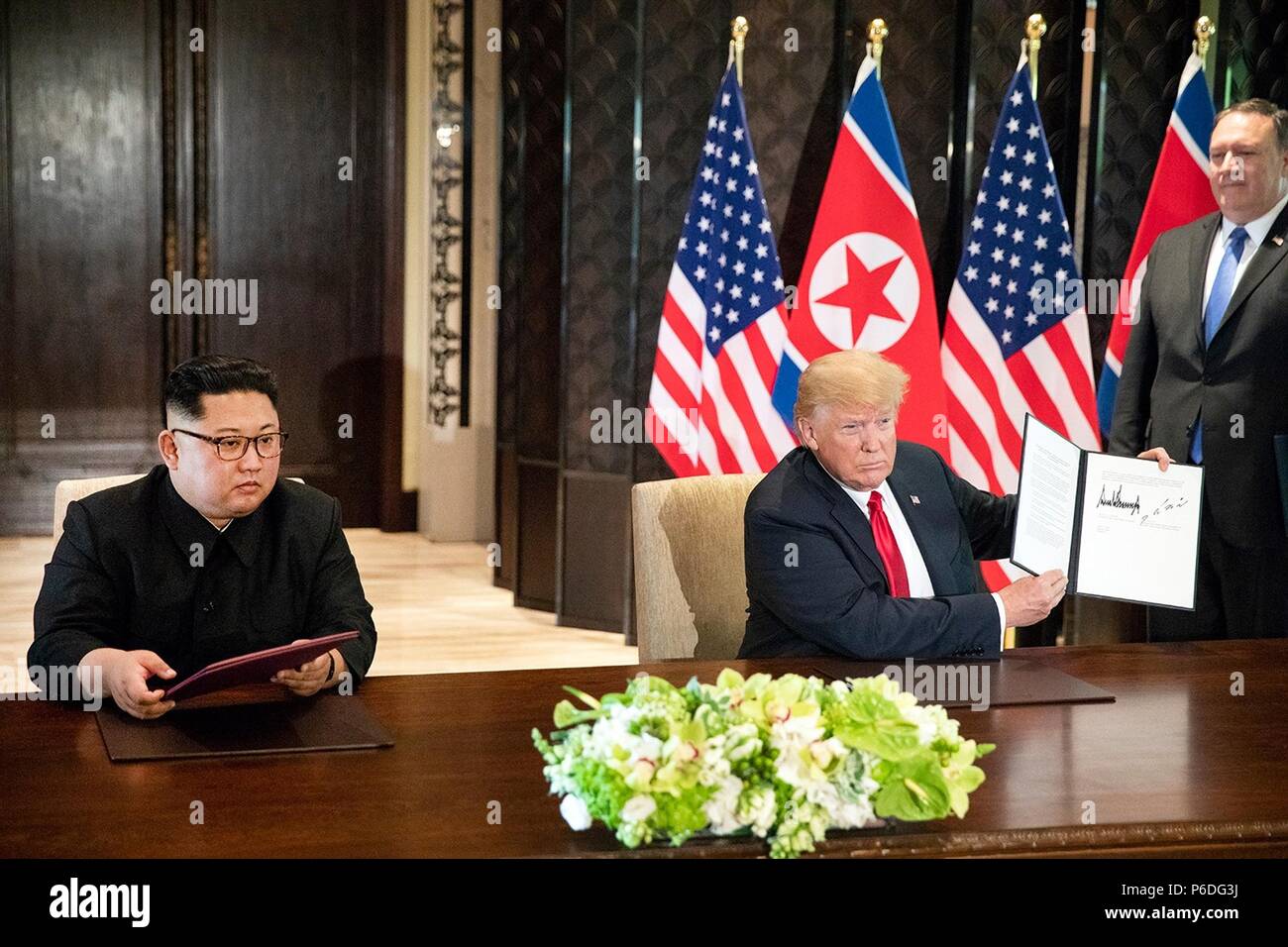 Us-Präsident Donald Trump, rechts, hält die unterzeichnete Vereinbarung als nordkoreanischen Führer Kim Jong Un an während einer Zeremonie an der Capella resort Juni 12, 2018 in Insel Sentosa, Singapur aussieht. Stockfoto