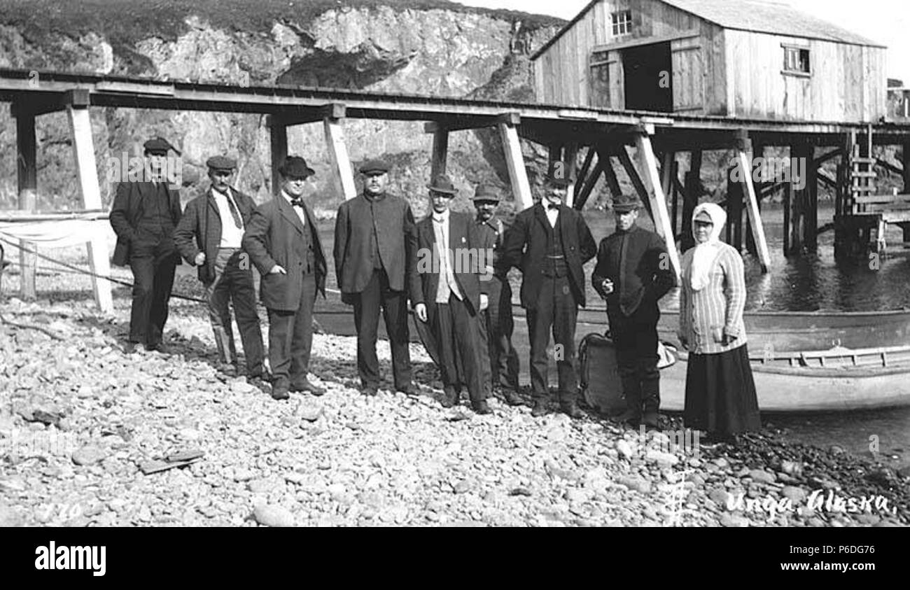 . Englisch: Gruppe von Menschen standen am Ufer in der Nähe von Boat Dock, Squaw Hafen, Unga Island, Ca. 1912. Englisch: Legende auf Bild: Unga, Alaska PH-Coll 247.221 Unga liegt an der südöstlichen Küste der Insel, in der VN-Generalversammlung Shumagin Inseln der Aleuten Kette. Es war ein aleut Dorf berichtete zuerst als "elarov" im Jahre 1833, mit einer Bevölkerung von 116, und dann als 'Ougnagok' 1836. Die 'Ounga' Post wurde im Jahr 1888 gegründet, und änderte seinen Namen in der VN-Generalversammlung im Jahr 1894. Die Post geschlossen im Jahr 1958. Vn-Generalversammlung nicht mehr belegt ist das ganze Jahr über. Themen (LCTGM): Squaw Hafen (Alaska); Unga Island (Alaska); Piers & wh Stockfoto
