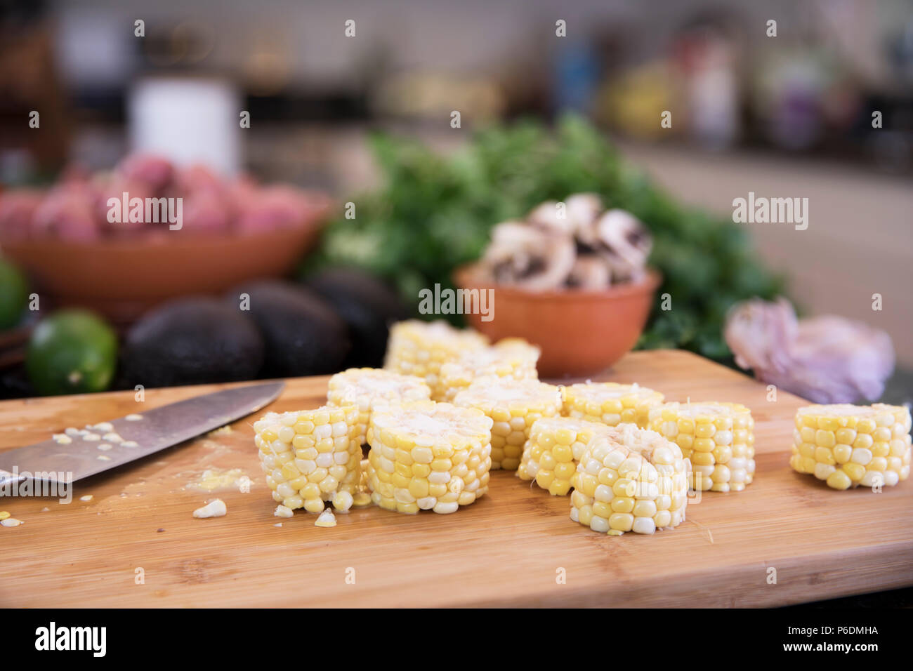 Maiskolben cut in Abschnitte auf Schneidebrett mit Messer für Suppe. Stockfoto