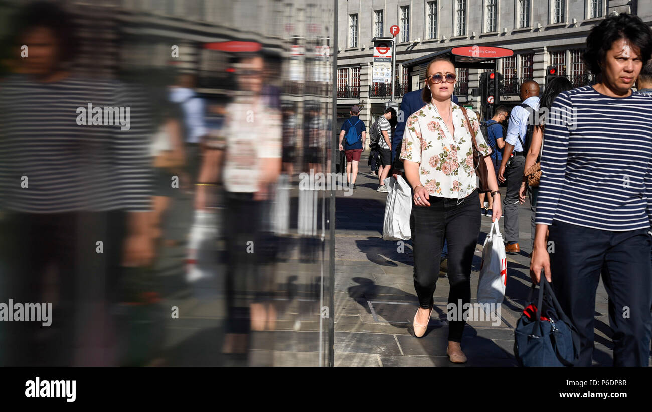 London, Großbritannien. 29. Juni 2018. UK Wetter - Pendler und Touristen zu Fuß die Regent Street hinunter sind in einem Pool von hellen Sonnenschein am frühen Abend erwischt. Die Prognose ist für warme Temperaturen in den nächsten Tagen fortzusetzen. Credit: Stephen Chung/Alamy leben Nachrichten Stockfoto