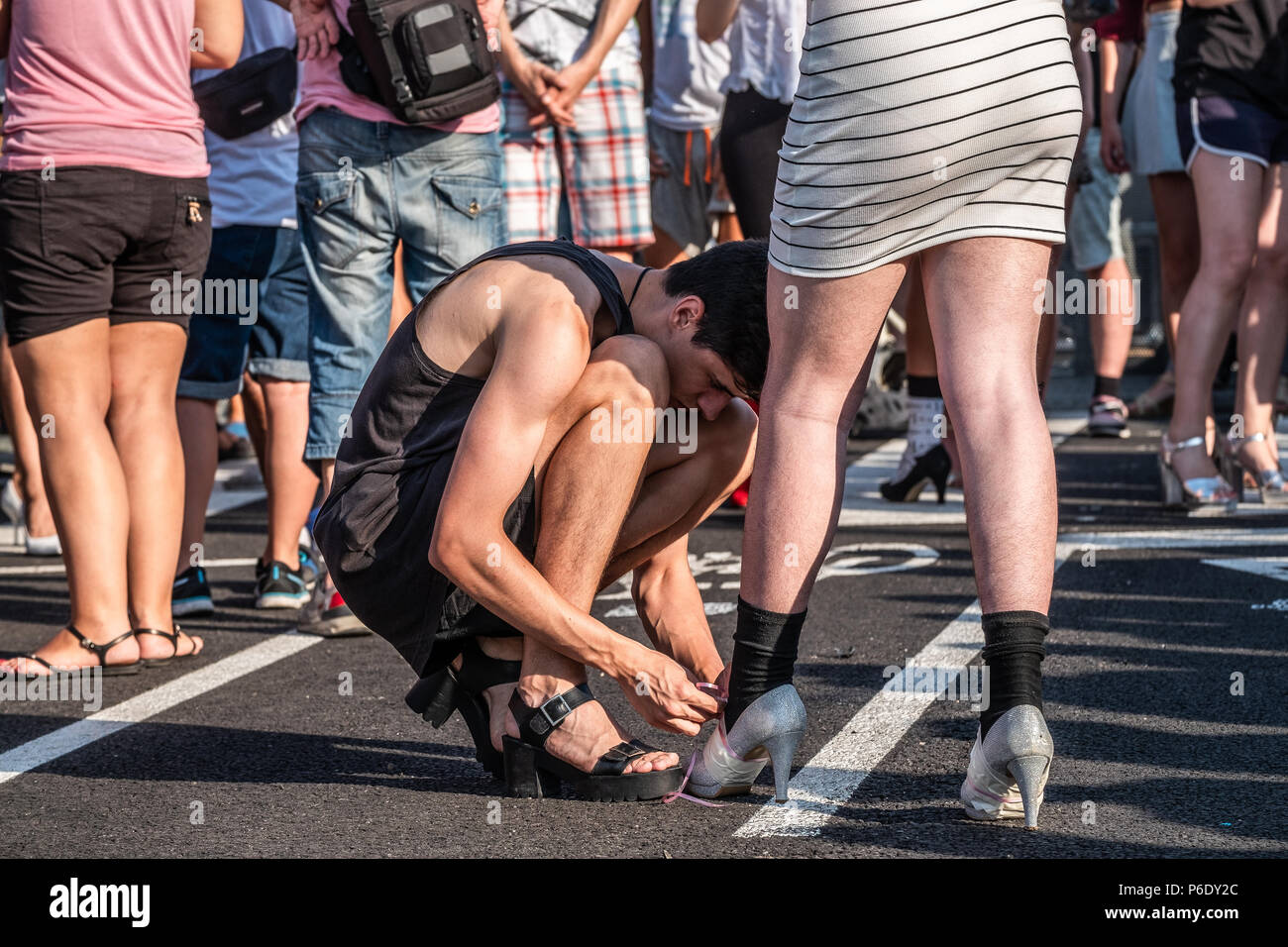 Ein Teilnehmer wird gesehen, das Binden der Schnürsenkel eines anderen Teilnehmers. Stolz Tag gefeiert wird am 28. Juni. Wie üblich in Barcelona, das so genannte Heels Rennen stattfindet. Es ist ein Rennen für alle Geschlechter, die Registrierung ist kostenlos und der Gewinner wird Pocket die 250 Euro Preisgeld. Stockfoto