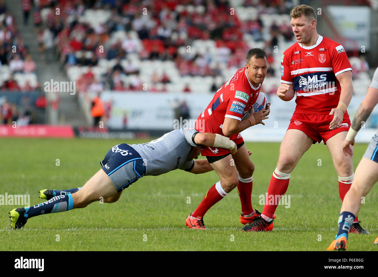 Der Rumpf Kr Danny McGuire ist von Huddersfield Riesen Ryan Hinchcliffe während der Betfred Super League Spiel im Craven Park, Hull in Angriff genommen. Stockfoto