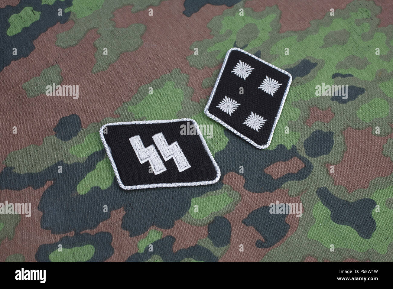WW 2 Deutsche Waffen-SS militärische Abzeichen auf SS Camouflage einheitlichen Hintergrund Stockfoto