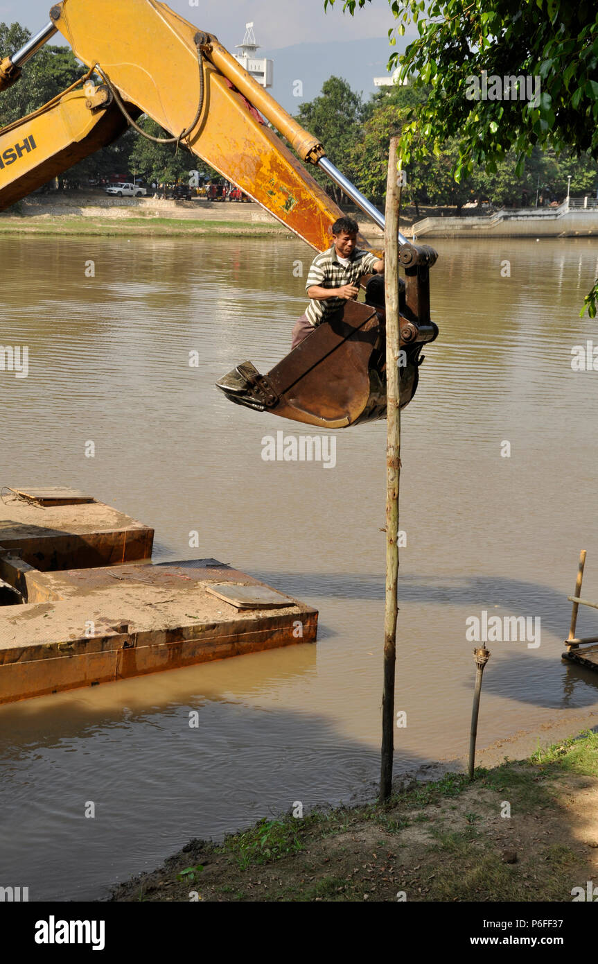 Ein steg Bau mit einem Bagger auf der Ping Fluss, diesem Arbeiter trägt keine persönliche Sicherheitsausrüstung, Chiang Mai, Thailand Stockfoto