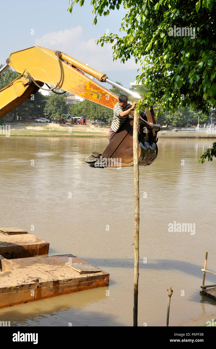 Ein steg Bau mit einem Bagger auf der Ping Fluss, diesem Arbeiter trägt keine persönliche Sicherheitsausrüstung, Chiang Mai, Thailand Stockfoto