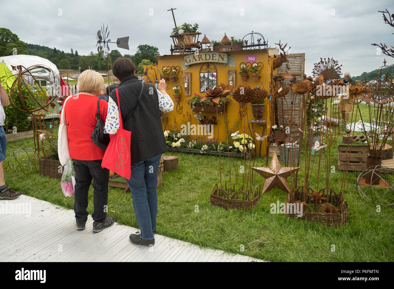 2 Frauen stehen, mit Blick auf die Anzeige der Garten Skulptur & Ornamente an an der RHS Flower Show, Chatsworth Chatsworth House, Derbyshire, England, UK Abschaltdruck Stockfoto