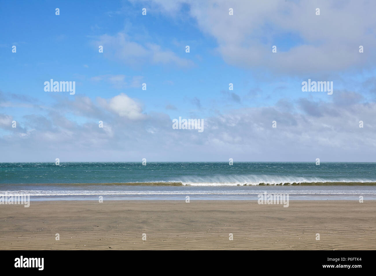 Blick vom Strand an der Westküste von Neuseeland auf die tazman Meer als eine Welle an der Küste bricht Stockfoto