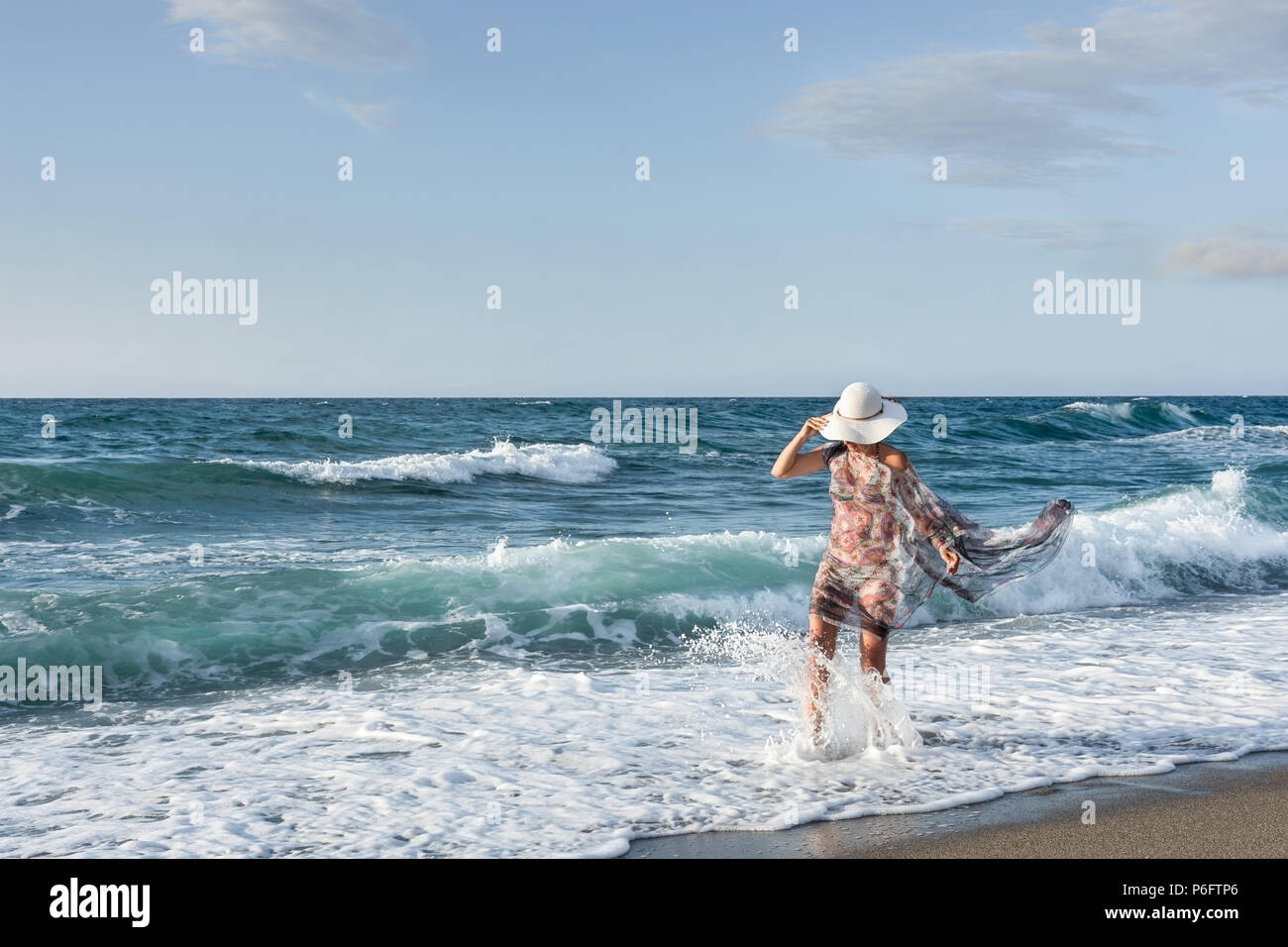 Eine Frau mit einem weißen Hut genießt das türkisfarbene Wasser des Meeres auf der Insel Kreta Stockfoto