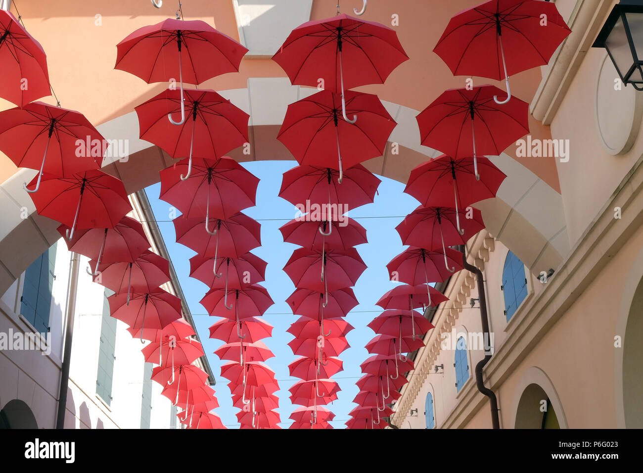 Viele rote Schirme fliegen im Himmel über city street in Venedig, Italien Stockfoto