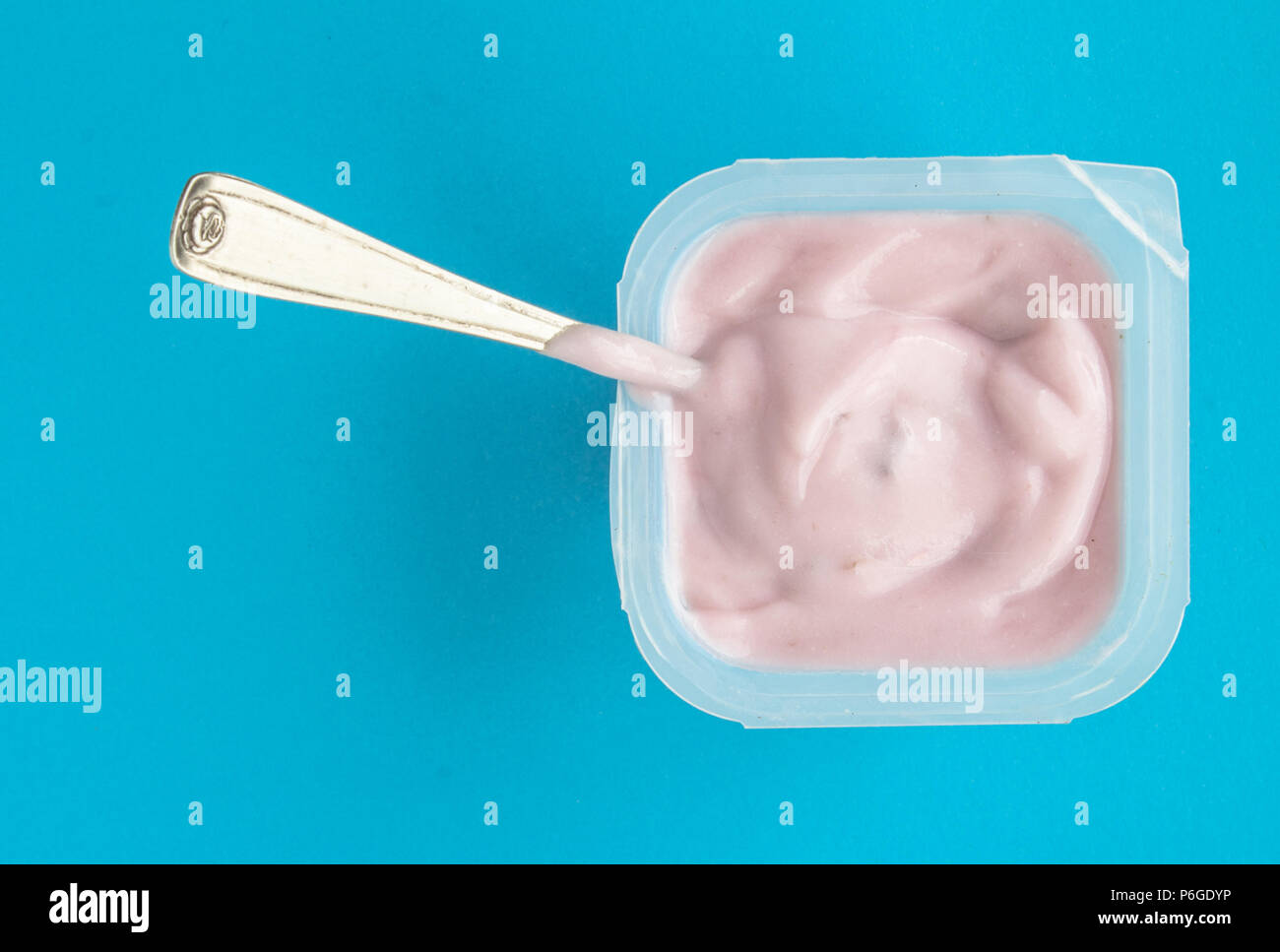 Joghurt im Becher close up-Rosa Joghurt auf blauem Hintergrund mit kleinen  silbernen Löffel Stockfotografie - Alamy