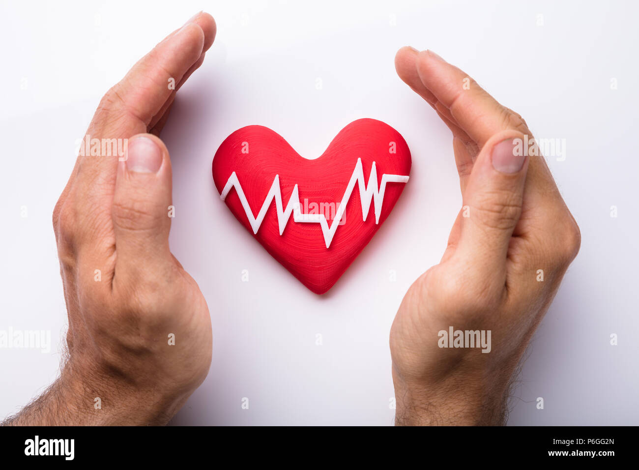 Die schützende Hand Herz mit Heartbeat isoliert auf weißem Hintergrund Stockfoto