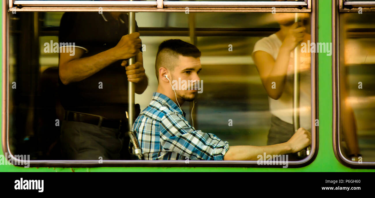 Belgrad, Serbien - Mai 31, 2018 : das Panning Schuß des jungen Mannes mit Kopfhörern in Plaid Shirt sitzen und andere Passagiere Reiten in einem Fenster Sitz einer c Stockfoto
