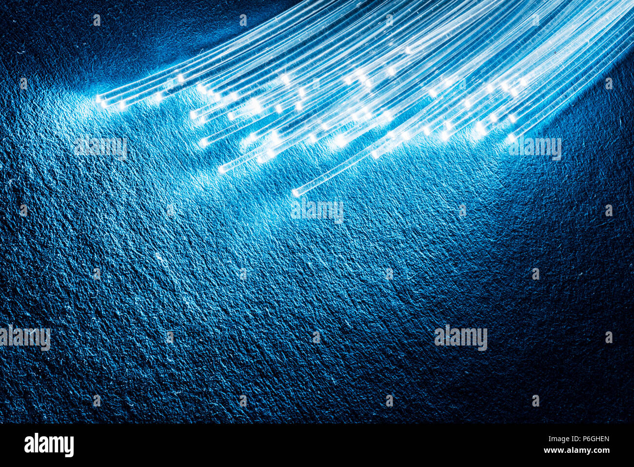 Bündel aus optischen Fasern mit Lichtern in den Enden. Blauen Hintergrund. Stockfoto