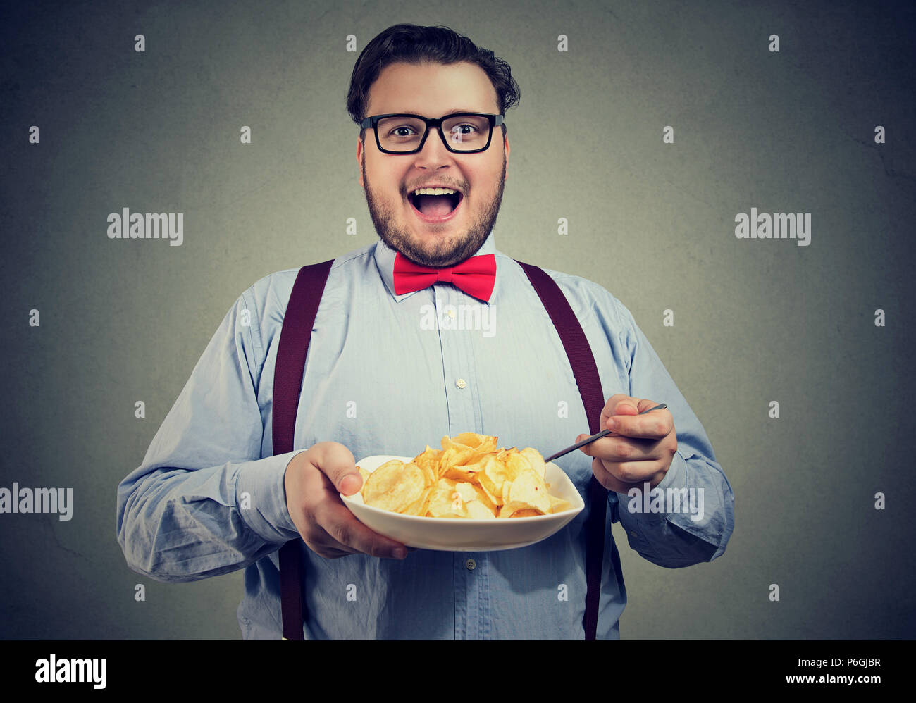 Junge aufgeregt Mann in einen Teller Chips Stockfoto