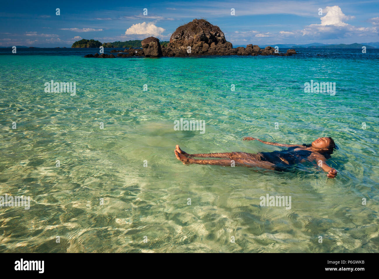 Panamasche Frau in klaren und transparenten Wassers auf der Insel Coiba Nationalpark, Pazifikküste, Provinz Veraguas, Republik Panama. Stockfoto