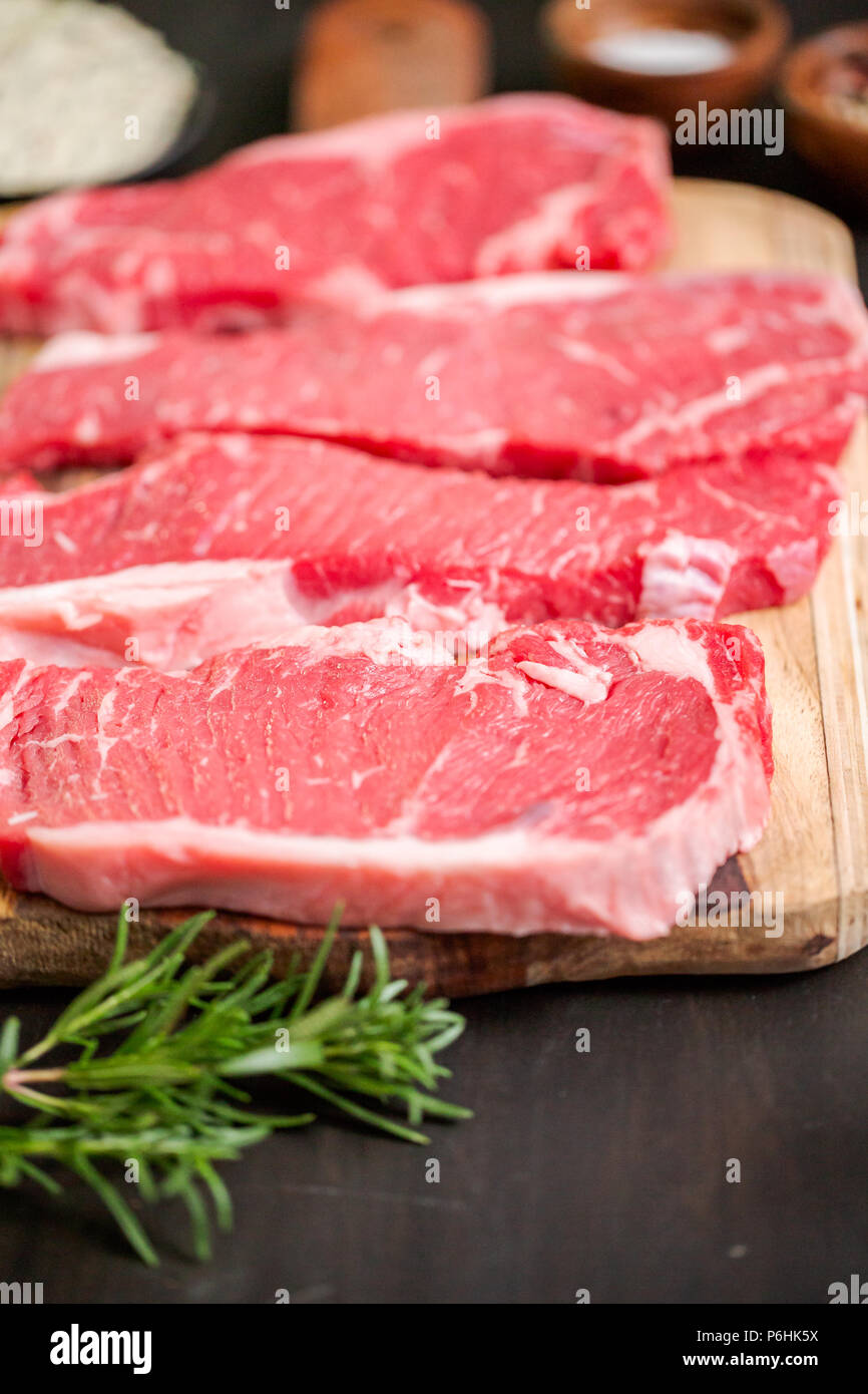Raw New York Strip Steak auf einem Holz Schneidebrett. Stockfoto