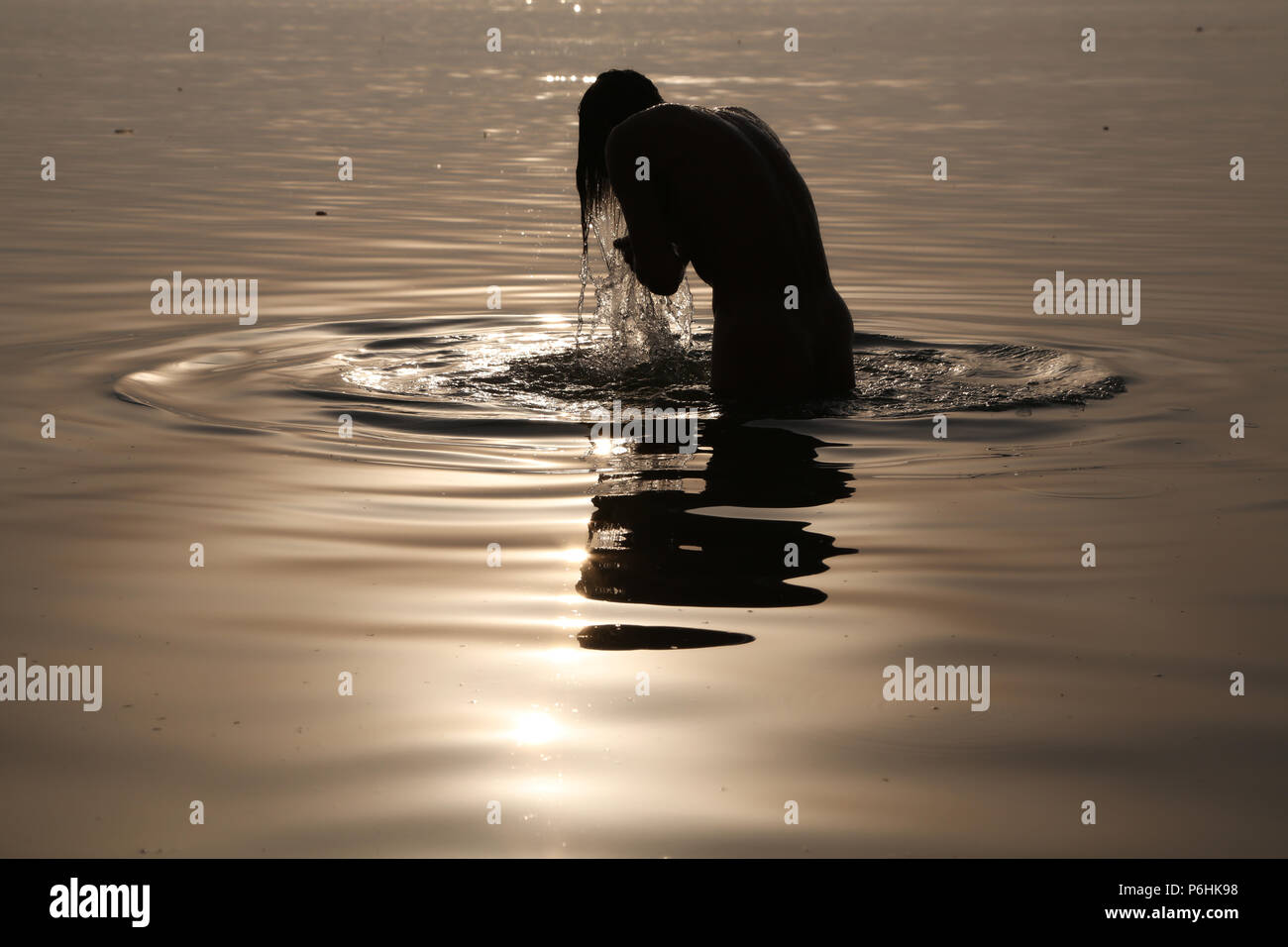 Der Mensch nimmt ein Bad im heiligen Wasser des Ganges Sangam während Maha Kumbh mela in Allahabad, Indien 2013 Stockfoto