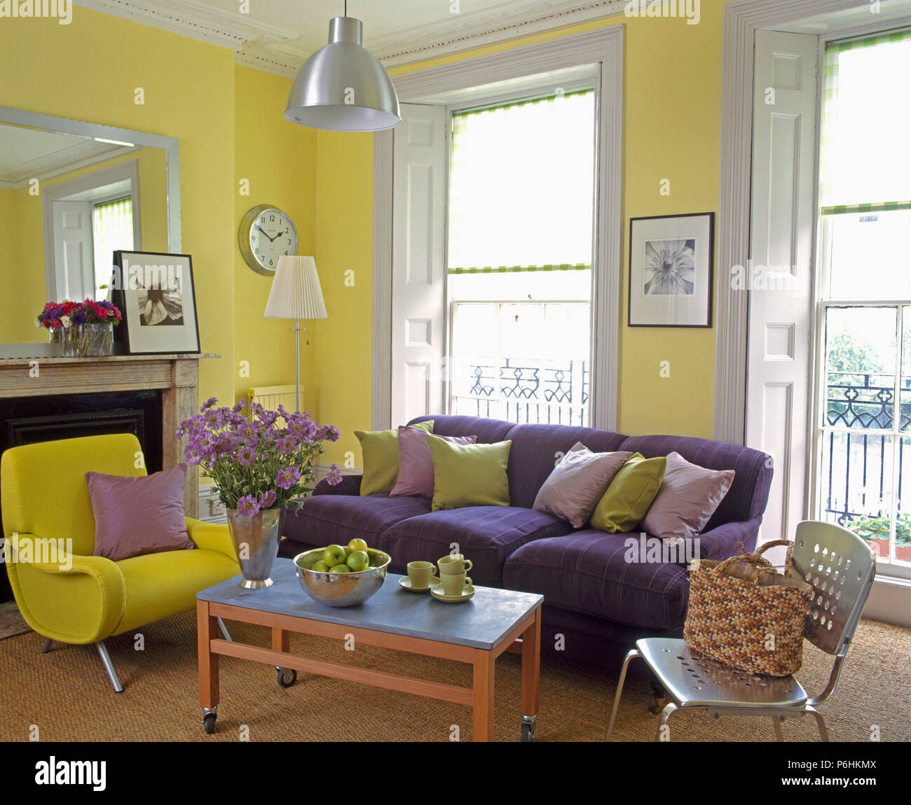 Lila Sofa und moderne gelb Sessel inl gelb Stadthaus Wohnzimmer mit Zink  Couchtisch und einem Metall Stuhl Stockfotografie - Alamy