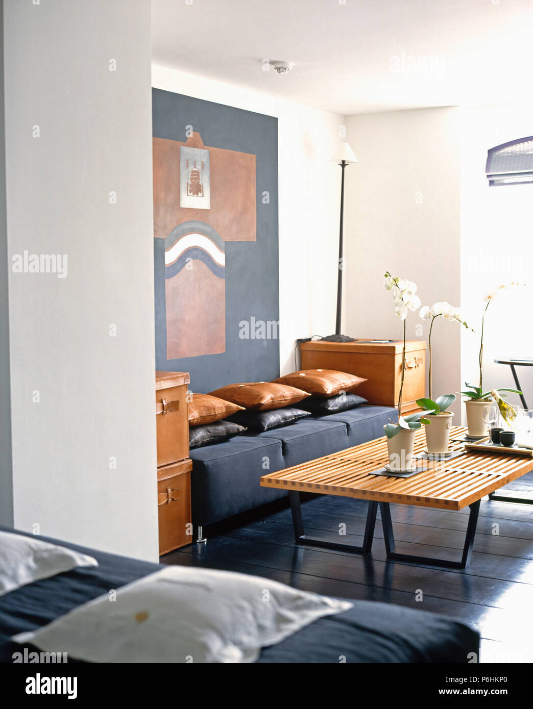 Leder Polster auf gepolsterten grauer Würfel Hocker in modernes Wohnzimmer mit einem Lattenrost Holz Couchtisch Stockfoto