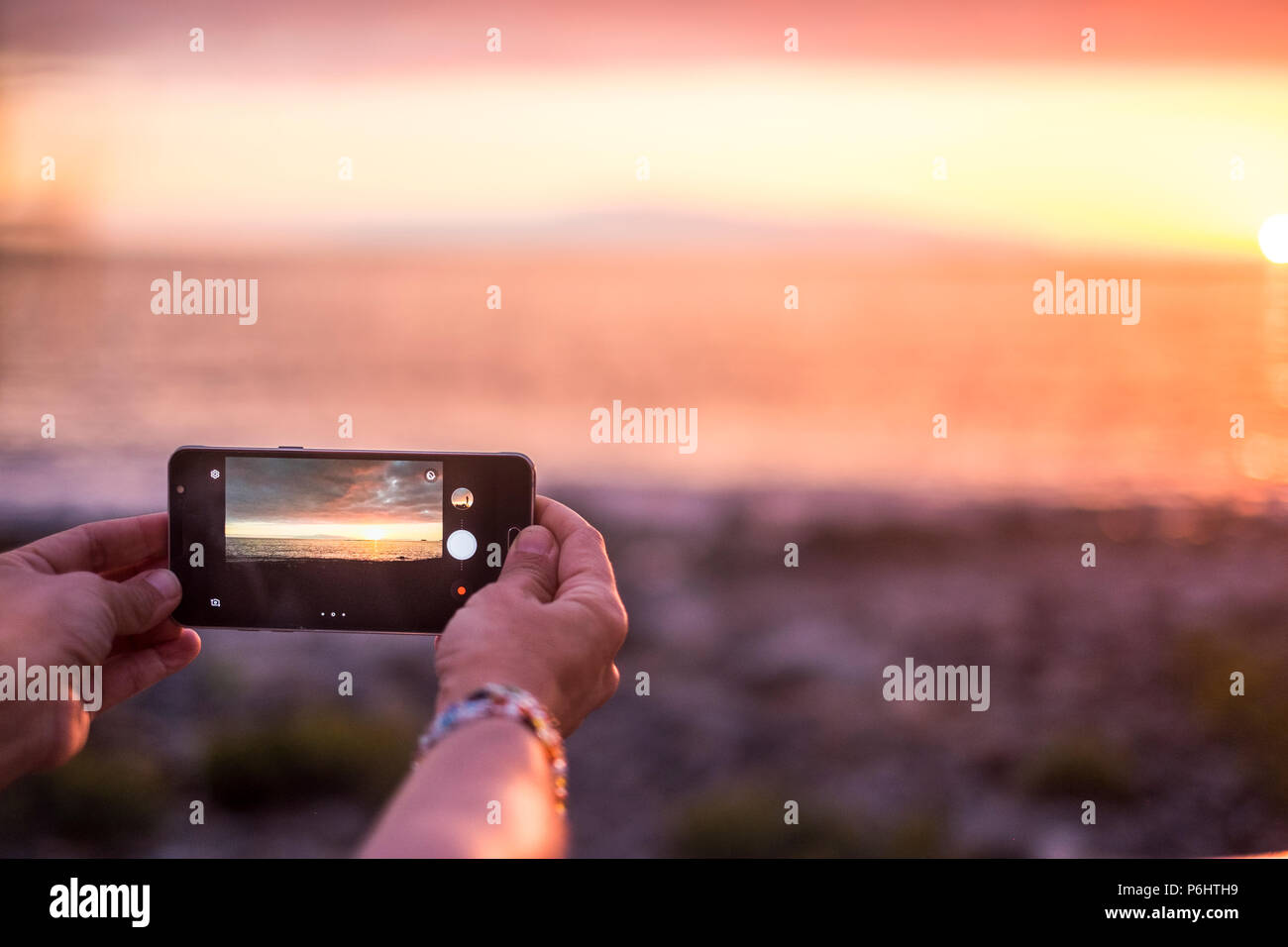 Frau nehmen Sie ein Bild auf den Sonnenuntergang am Meer im Sommer Urlaub. von Ihrem smartpho0ne mit der Vorschau auf das Ergebnis gesehen. Technologie memory Collection Stockfoto
