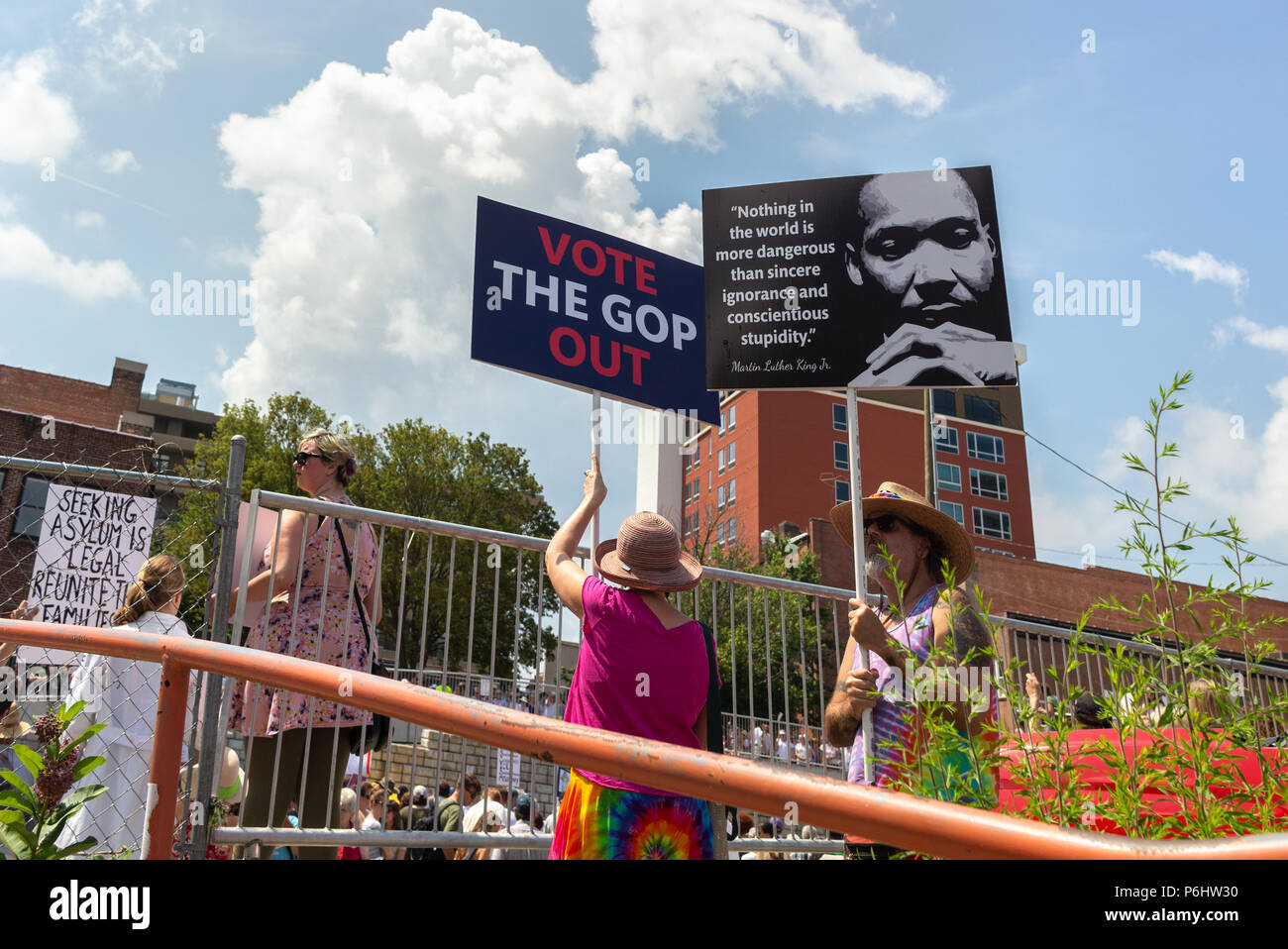 Die Demonstranten halten Schilder gegen den bewölkten Himmel bei der Familien gehören zusammen in Asheville, NC, USA Rallye Stockfoto